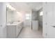 Bright bathroom featuring double vanity, updated fixtures, a glass shower and tile flooring at 10032 Sw 85Th Place Rd, Ocala, FL 34481
