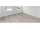 Bright bedroom with light wood floors, two windows, and white trim at 10032 Sw 85Th Place Rd, Ocala, FL 34481