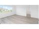 A bright bedroom with a large window and light wood floors at 10032 Sw 85Th Place Rd, Ocala, FL 34481