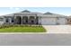 Inviting home with a well-kept lawn, a three-car garage, and stylish stone columns on the front porch at 10032 Sw 85Th Place Rd, Ocala, FL 34481
