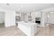 Bright kitchen featuring white cabinets, mosaic backsplash, stainless appliances, and an island with quartz countertops at 10032 Sw 85Th Place Rd, Ocala, FL 34481
