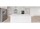 Bright kitchen featuring white cabinets, mosaic backsplash, stainless appliances, and an island with quartz countertops at 10032 Sw 85Th Place Rd, Ocala, FL 34481