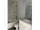 Bathroom features a tiled shower and tub combo with a granite vanity at 10385 Se 125Th Ln, Belleview, FL 34420