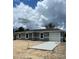 Charming one-story home with a gray exterior, white trim, and a newly-poured concrete driveway at 10385 Se 125Th Ln, Belleview, FL 34420