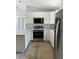 Modern kitchen with white cabinetry, granite countertops, and stainless steel appliances at 10385 Se 125Th Ln, Belleview, FL 34420