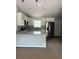 An open concept kitchen features white cabinets, granite countertops, and stainless steel appliances at 10385 Se 125Th Ln, Belleview, FL 34420