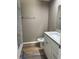 Bathroom with modern vanity, granite countertop, and tiled shower at 10401 Se 125Th Ln, Belleview, FL 34420
