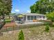 Aerial view of the backyard featuring a patio, deck, and screened-in porch surrounded by a black fence at 10459 Sw 62Nd Ct, Ocala, FL 34476