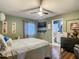 Bedroom features a ceiling fan, flat screen TV, and view into ensuite bathroom at 10459 Sw 62Nd Ct, Ocala, FL 34476