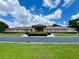 Well-maintained clubhouse exterior showcasing manicured landscaping, mature trees, and inviting entryway with circular drive at 10459 Sw 62Nd Ct, Ocala, FL 34476