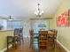 Open dining area with barstool seating, wood floors, and stylish chandelier at 10459 Sw 62Nd Ct, Ocala, FL 34476