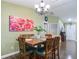 Dining room with wood floors, table with six chairs, and a floral art piece at 10459 Sw 62Nd Ct, Ocala, FL 34476