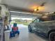 Spacious garage with epoxy floor, and car parked near the partially open garage door at 10459 Sw 62Nd Ct, Ocala, FL 34476