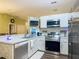 A kitchen is equipped with stainless steel appliances, white cabinets, and a bar top at 10459 Sw 62Nd Ct, Ocala, FL 34476