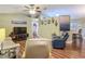The spacious living room has hardwood floors, a ceiling fan, and comfortable seating arrangements at 10459 Sw 62Nd Ct, Ocala, FL 34476