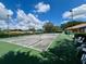 Outdoor tennis court within a well-maintained community setting, surrounded by lush greenery and clear skies at 10459 Sw 62Nd Ct, Ocala, FL 34476