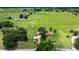 Stunning aerial view of a charming home with large lawn, pastures, and mature trees at 12131 Ne 10Th Ter, Ocala, FL 34479