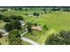 Wide aerial shot of a property with pastures and horse shelters, including a neutral colored home at 12131 Ne 10Th Ter, Ocala, FL 34479