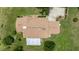 Aerial view of a home with a brown roof, a large driveway, and surrounded by a lush green lawn with sparse trees at 12131 Ne 10Th Ter, Ocala, FL 34479