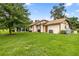 Spacious backyard with lush green grass, mature trees, and an enclosed porch at 12131 Ne 10Th Ter, Ocala, FL 34479