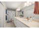 Bathroom with a double vanity, a large mirror, and a shower with a floral curtain at 12131 Ne 10Th Ter, Ocala, FL 34479