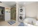 Bathroom featuring a soaking tub, stacked washer and dryer, and a glass-enclosed shower at 12131 Ne 10Th Ter, Ocala, FL 34479