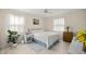 Cozy bedroom with a white bed, a ceiling fan, and natural light from the windows at 12131 Ne 10Th Ter, Ocala, FL 34479