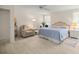 Bright bedroom with a wicker headboard, ceiling fan, recliner and lots of natural light at 12131 Ne 10Th Ter, Ocala, FL 34479