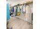 Walk-in closet showcasing clothing hanging on racks with light wooden floors and ample storage space at 12131 Ne 10Th Ter, Ocala, FL 34479