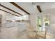 Eat-in kitchen featuring a glass table set and white cabinetry with sleek countertops and wood beams at 12131 Ne 10Th Ter, Ocala, FL 34479