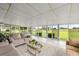 Bright sun room with ample seating, large windows, and views of the landscaped backyard at 12131 Ne 10Th Ter, Ocala, FL 34479