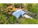 Aerial view of a charming home featuring a screened-in porch and a spacious driveway surrounded by lush greenery at 12320 Sw 62Nd Pl, Ocala, FL 34481