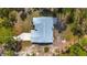 An aerial view showcasing the home's roofline and features including a screened patio, all set amidst a backdrop of wooded land at 12320 Sw 62Nd Pl, Ocala, FL 34481