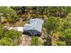 Overhead view captures a home with an extended driveway and serene wooded surroundings, creating a private and picturesque setting at 12320 Sw 62Nd Pl, Ocala, FL 34481