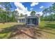 The backyard shows the screened porch and big yard of the house near wooded area at 12320 Sw 62Nd Pl, Ocala, FL 34481