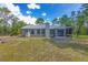 Backyard of the house shows big yard, screened porch, and space for sitting at 12320 Sw 62Nd Pl, Ocala, FL 34481
