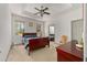 Bright bedroom with large windows, tray ceiling, ceiling fan, and neutral color palette at 12320 Sw 62Nd Pl, Ocala, FL 34481