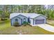 Charming single story home with well-manicured lawn, grey paint and 2 car garage at 12320 Sw 62Nd Pl, Ocala, FL 34481