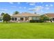 Large backyard with lush green grass and several windows for ample light throughout the interior at 15549 Sw 11Th Terrace Rd, Ocala, FL 34473