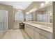 Luxurious bathroom featuring double sinks, marble countertops, large mirror, and a window for natural light at 15549 Sw 11Th Terrace Rd, Ocala, FL 34473