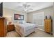 Cozy bedroom with comfortable bed, ceiling fan, plantation shutters, and wood-look floors at 15549 Sw 11Th Terrace Rd, Ocala, FL 34473