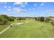 Scenic aerial view of a golf course with players, golf carts, sand traps, and lush landscaping under a sunny sky at 15549 Sw 11Th Terrace Rd, Ocala, FL 34473