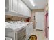 Well-equipped laundry room with modern washer, dryer, storage cabinets, and tiled floor at 15549 Sw 11Th Terrace Rd, Ocala, FL 34473