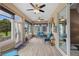 Enclosed sunroom with ceiling fans, natural light, wood-look floors, and access to an outdoor patio at 15549 Sw 11Th Terrace Rd, Ocala, FL 34473