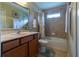 Bathroom featuring tiled shower and tub, marble countertop, and warm brown cabinets with decorative touches at 16215 Sw 15Th Ct, Ocala, FL 34473