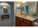 Bathroom with wood cabinets, marble counters, decorative vases, and an arched doorway to the hallway at 16215 Sw 15Th Ct, Ocala, FL 34473