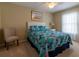 Bright bedroom featuring a ceiling fan, floral bedding, a window with curtains, and neutral wall color at 16215 Sw 15Th Ct, Ocala, FL 34473