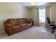 Bedroom with neutral walls, carpet flooring, a brown sofa, and a window with curtains at 16215 Sw 15Th Ct, Ocala, FL 34473