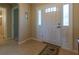 Bright entryway featuring a white front door with decorative glass and tiled flooring, leading into the home at 16215 Sw 15Th Ct, Ocala, FL 34473