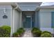 Inviting front entrance with stone walkway and lush landscaping leading to the home's teal-colored door at 16215 Sw 15Th Ct, Ocala, FL 34473